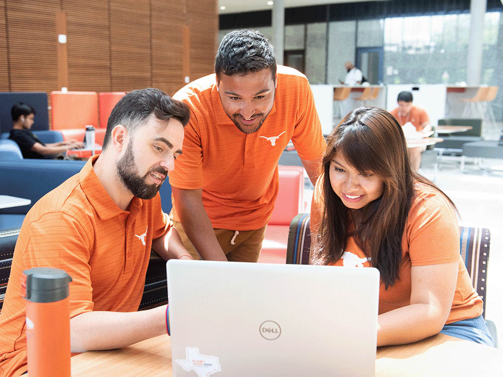 master degree students looking at laptop